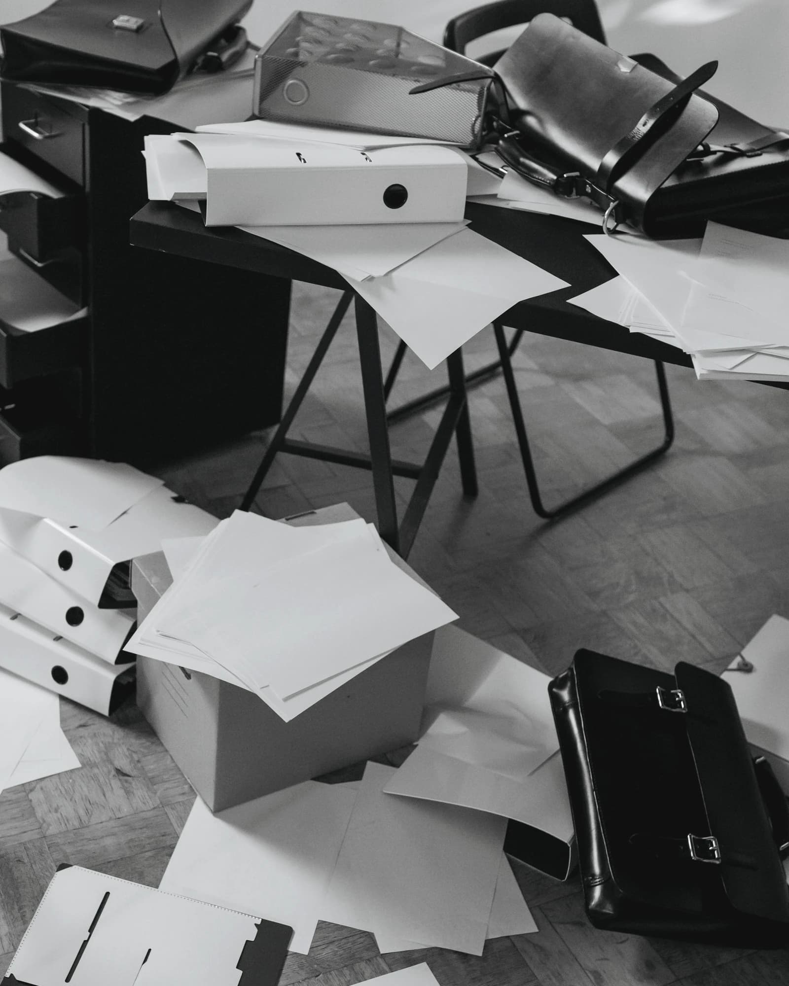 Papeles y archivadores desbordados que reflejan caos operativo y retrabajo por depender de Excel