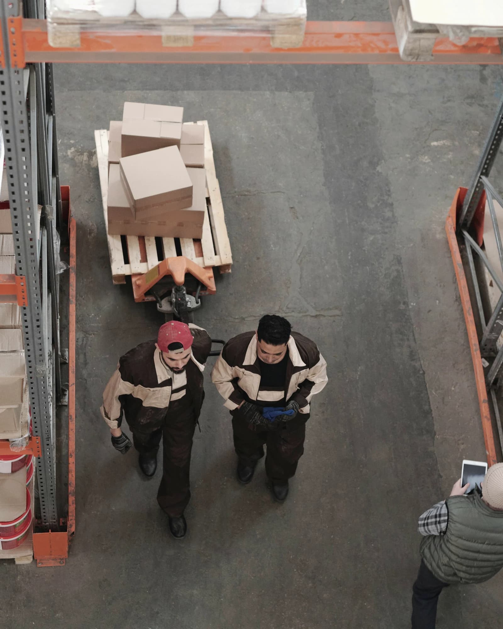 Operarios y pallets en nave logística con flujo de distribución visible