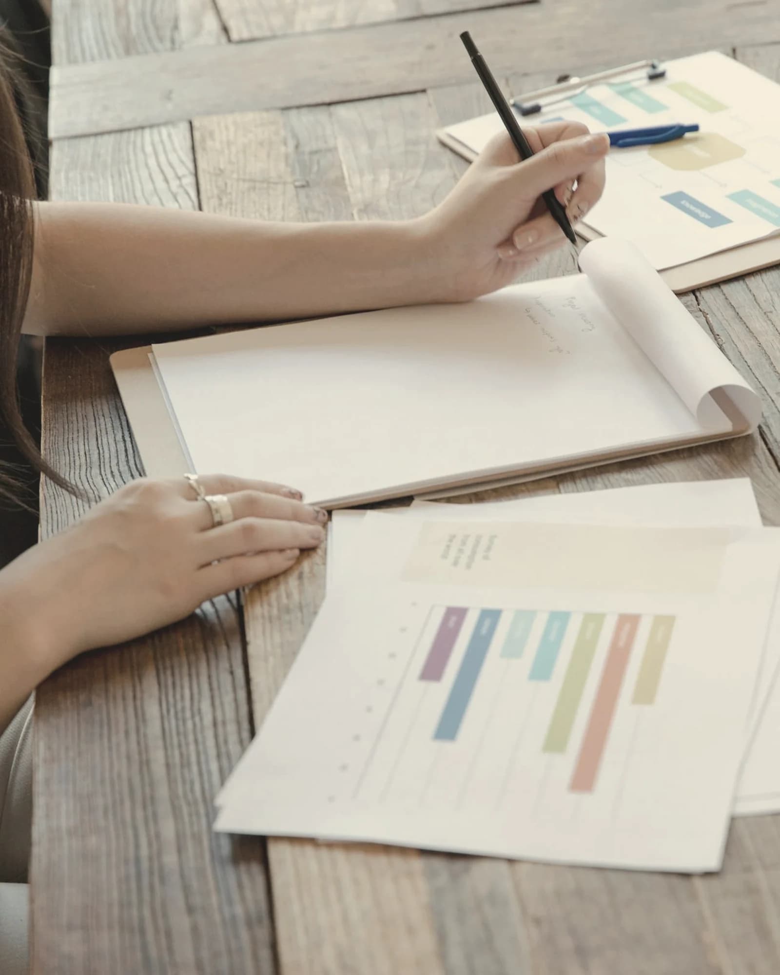 Persona tomando notas sobre documentos para representar dudas frecuentes antes de sustituir Excel como sistema