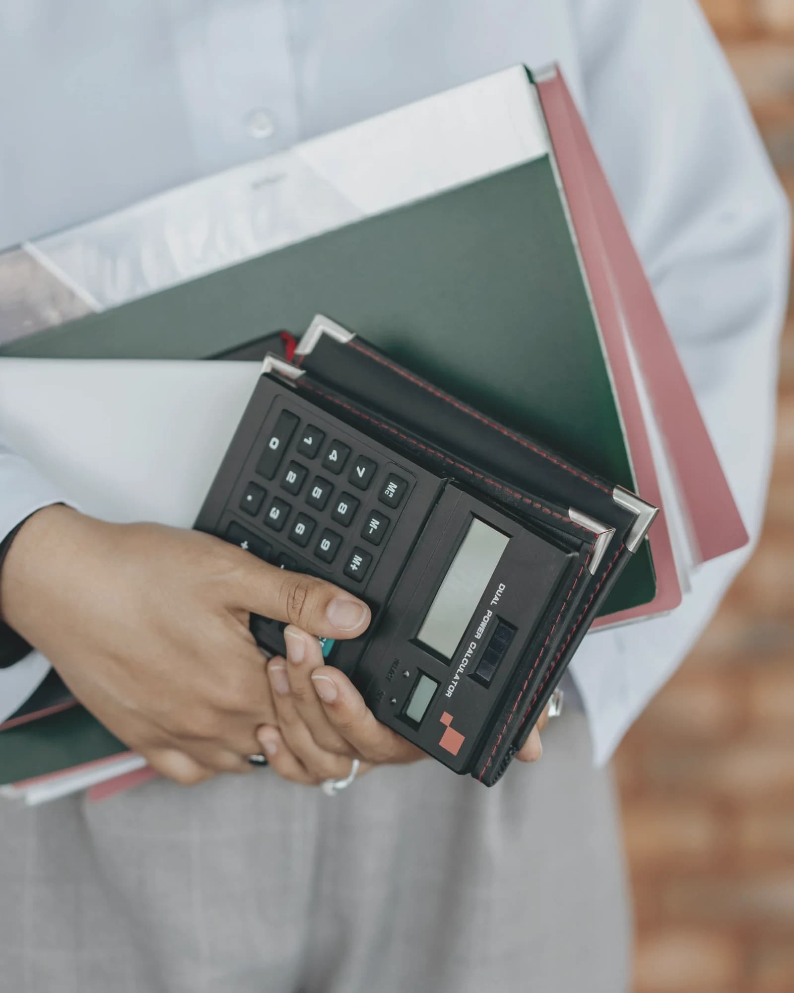 Persona con carpetas y calculadora para representar KPIs operativos medibles sin inventar cifras